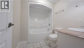Hamilton condo for rent - A white bathroom with a toilet, sink and shower.