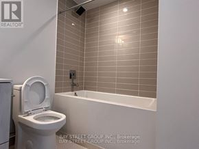 Toronto (Church-Yonge Corridor) condo for rent - A white toilet sits next to a bathtub in a bathroom.