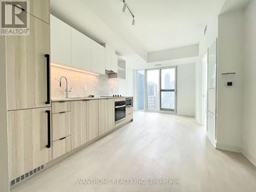 Toronto (Church-Yonge Corridor) condo for rent - A modern kitchen with wooden cabinets and a large window.