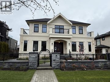 Vancouver apartment for rent - A large, two-story house with a black gate and a brick walkway leading to the entrance.