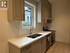 Vancouver apartment for rent - A kitchen with a sink, stove, and cabinets.