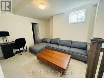 Oakville (Go Glenorchy) townhouse for rent - A living room with a grey couch and a wooden coffee table.