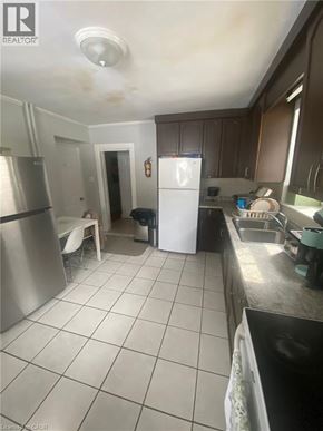 Guelph apartment for rent - A kitchen with a white fridge and a stainless steel oven.