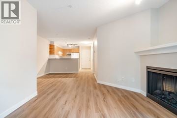 Burnaby apartment for rent - A living room with a fireplace and a view of a kitchen.