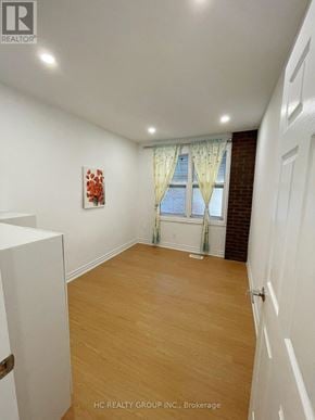 Toronto (Broadview North) apartment for rent - A room with wooden flooring and a window with curtains.