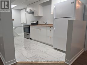 Barrie (Grove East) apartment for rent - A kitchen with white cabinets and a white fridge.
