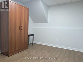 Barrie (Grove East) apartment for rent - A room with a wooden cabinet and a small table.