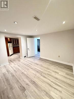 Newmarket (Central Newmarket) apartment for rent - A spacious room with wood flooring and a kitchen area in the background.
