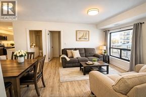 Windsor condo for rent - A well-lit living room with a dining table and a couch.