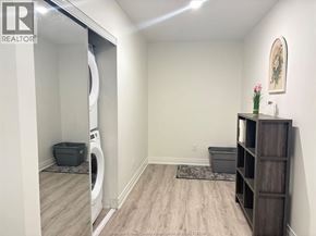 Windsor condo for rent - A laundry room with a washer and dryer, a rug, and a wooden shelf.