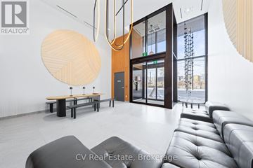 Toronto (Junction Area) condo for rent - A modern living room with a grey sofa and a wooden table.