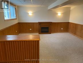 Niagara Falls (Morrison) apartment for rent - A room with a fireplace and wooden paneling.