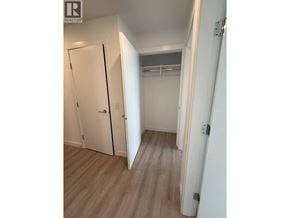 New Westminster apartment for rent - A white door is open to a room with a white wall and a white closet with a coat rack.