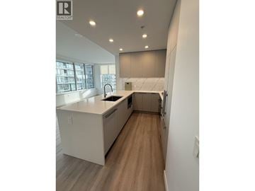 New Westminster apartment for rent - A modern kitchen with white cabinets and a wooden floor.