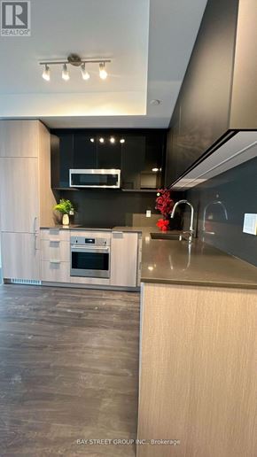 Toronto (Church-Yonge Corridor) condo for rent - A modern kitchen with a white oven and wooden cabinets.