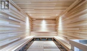 Barrie (City Centre) condo for rent - A wooden sauna with a bench in the middle.