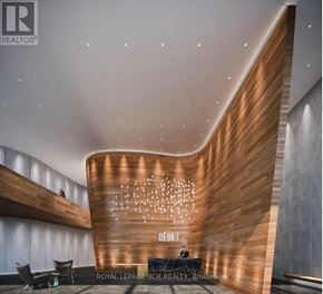 Barrie (City Centre) condo for rent - A reception area with a wood panelled wall and a sign that says Debit.