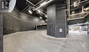 Barrie (City Centre) condo for rent - A large, empty warehouse with a dirt floor and concrete walls.