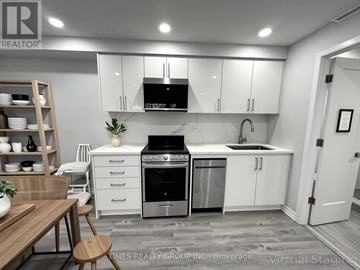 Toronto (Annex) multi-family for rent - A modern kitchen with white cabinets and stainless steel appliances.