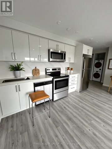Toronto (Annex) multi-family for rent - A modern kitchen with white cabinets and a wooden floor.