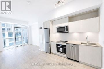Toronto (Moss Park) condo for rent - A kitchen with white cabinets and stainless steel appliances.