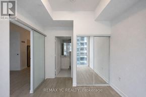 Toronto (Moss Park) condo for rent - A brokerage sign is on the wall of a large, empty room.