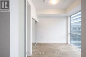 Toronto (Moss Park) condo for rent - A room with a large window and a wooden floor.