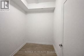 Toronto (Moss Park) condo for rent - A small, empty room with a wooden floor and white walls.