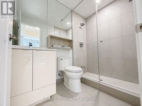 Toronto (Moss Park) condo for rent - A white toilet is in a bathroom with a glass shower stall.