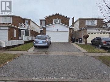 Brampton (Fletcher's West) apartment for rent - A grey car is parked in front of a white garage.