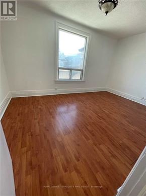 Toronto (Dovercourt-Wallace Emerson-Junction) triplex for rent - A room with wooden flooring and a window.