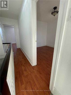 Toronto (Dovercourt-Wallace Emerson-Junction) triplex for rent - A hallway with wood floors and white walls.