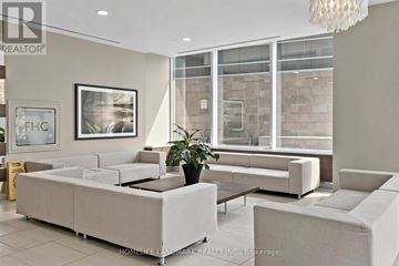 Toronto (Moss Park) condo for rent - A well-lit living room with a large sofa and a coffee table.