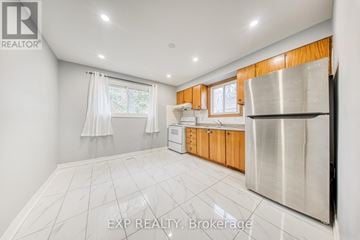 Toronto (Oakridge) apartment for rent - A kitchen with white tiled floors and wooden cabinets.