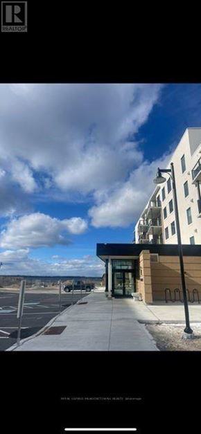 Kawartha Lakes (Fenelon Falls) condo for rent - A building with a large entrance and a parking lot in front.