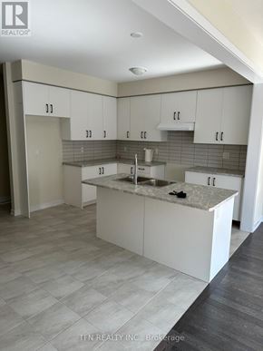 Haldimand apartment for rent - A kitchen with white cabinets and a marble countertop.