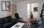 Ajax (Central) apartment for rent - A living room with a black couch and a coffee table.