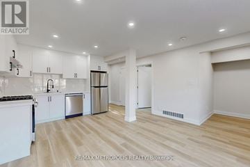 Toronto (Humber Summit) fourplex for rent - A spacious kitchen with white cabinets and a wooden floor.