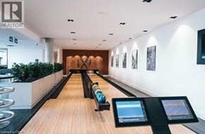 Kitchener condo for rent - A bowling alley with a row of bowling lanes and a screen on the right side.