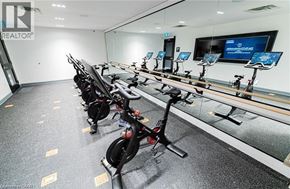 Kitchener condo for rent - A row of stationary bikes are lined up in a room.