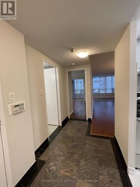 Toronto (Newtonbrook East) condo for rent - A hallway with a light switch and a door at the end.