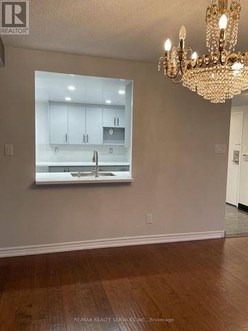 Toronto (Newtonbrook East) condo for rent - A chandelier hangs over a kitchen counter in a well-lit room.