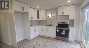 Georgina (Keswick South) apartment for rent - A kitchen with white cabinets and a black fridge.