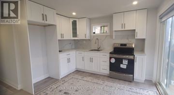 Georgina (Keswick South) apartment for rent - A kitchen with white cabinets and a black fridge.