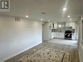 Georgina (Keswick South) apartment for rent - A well-lit, empty room with a rug on the floor and a kitchen area visible through the door.