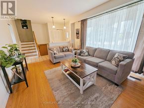 Hamilton (Berrisfield) apartment for rent - A living room with a grey couch, a coffee table, and a staircase.