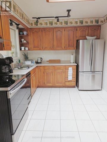 Hamilton (Berrisfield) apartment for rent - A kitchen with wooden cabinets and a black stove top oven.