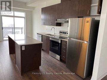Milton (Fo Ford) condo for rent - A kitchen with a stainless steel refrigerator and a wooden island.