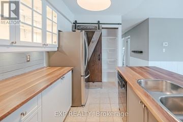 Clarington (Bowmanville) condo for rent - A kitchen with a wooden counter top and white cabinets.