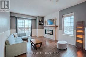 Clarington (Bowmanville) condo for rent - A living room with a grey couch, a wooden coffee table, a fireplace, and a flat screen TV mounted above it.